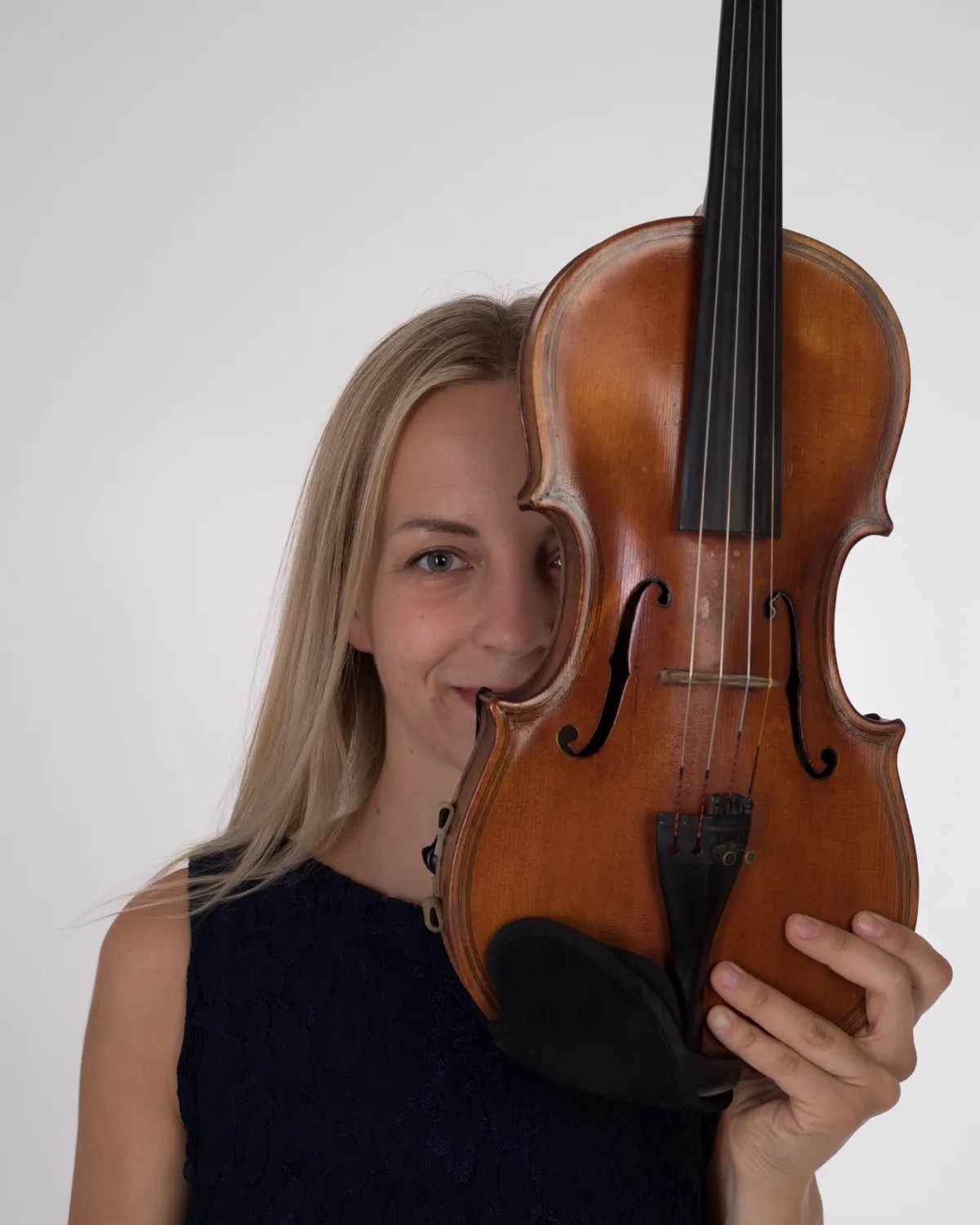 Marta smiling from behind her violin